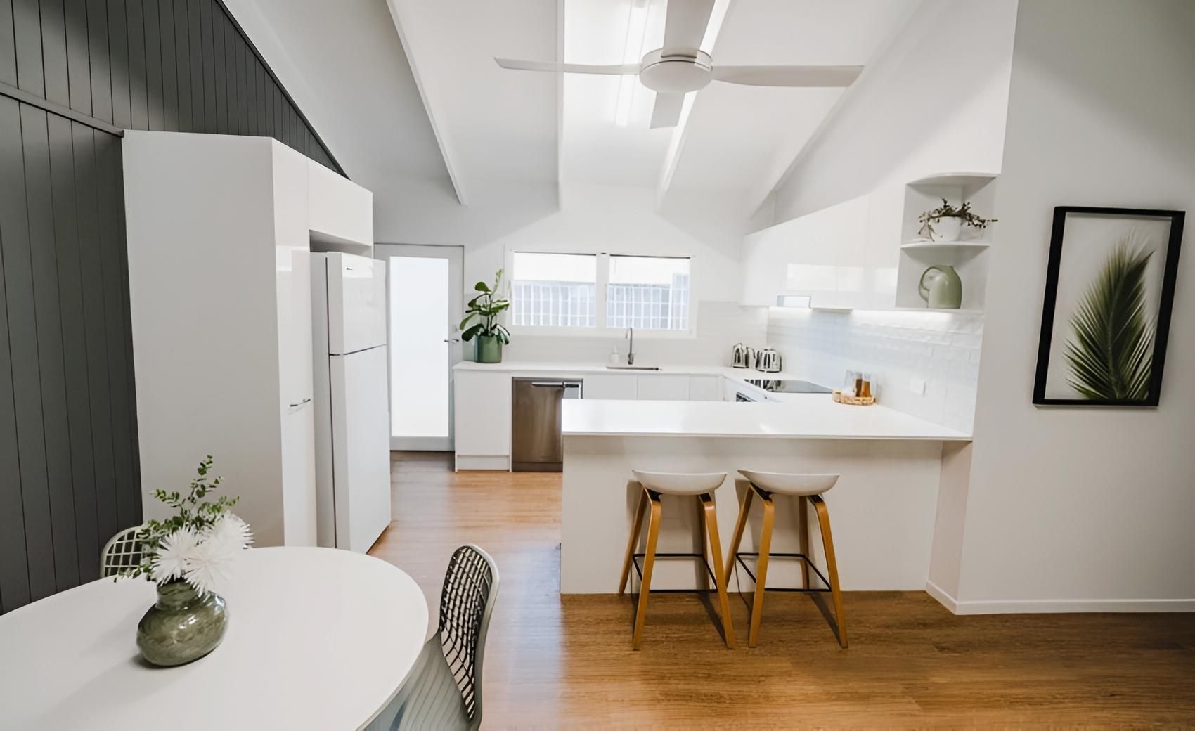 A Kitchen With a Table and Stools and a Ceiling Fan — CK Cabinetry in Coolum Beach, QLD