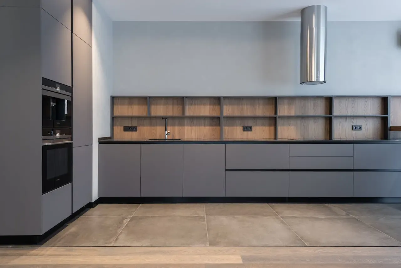 A Modern Kitchen With Gray Cabinets and a Stainless Steel Hood — CK Cabinetry in Coolum Beach, QLD