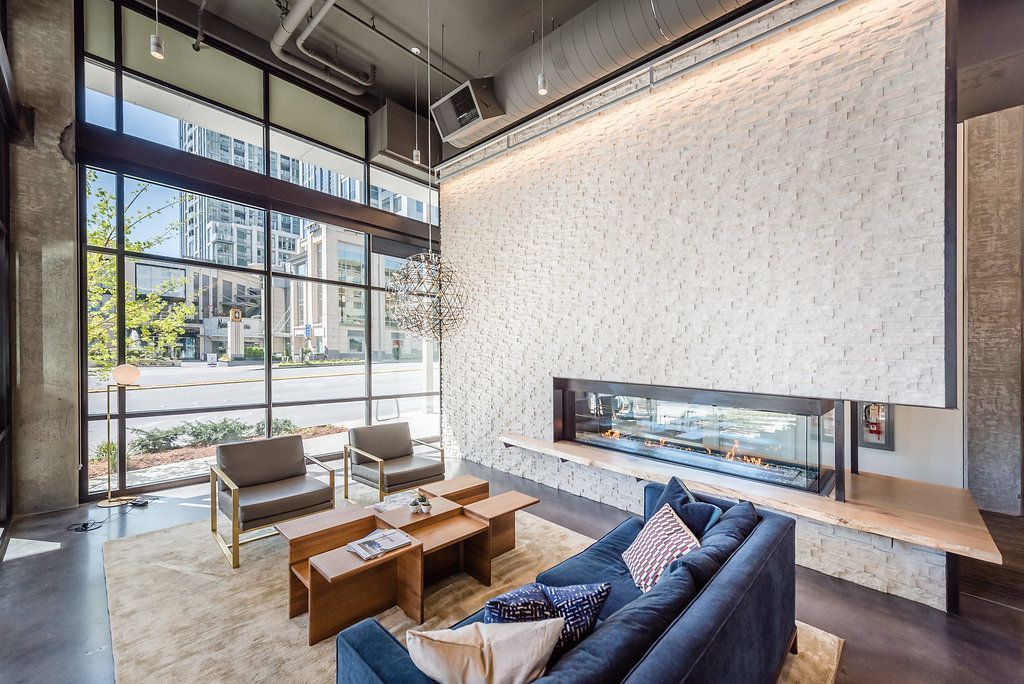 Resident lounge with a couch, chairs, coffee tables, and a fireplace.
