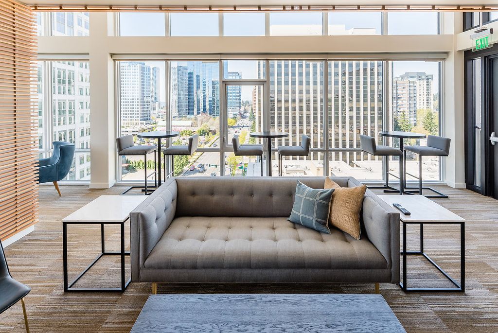 Clubhouse with a couch, chairs, tables, and windows.