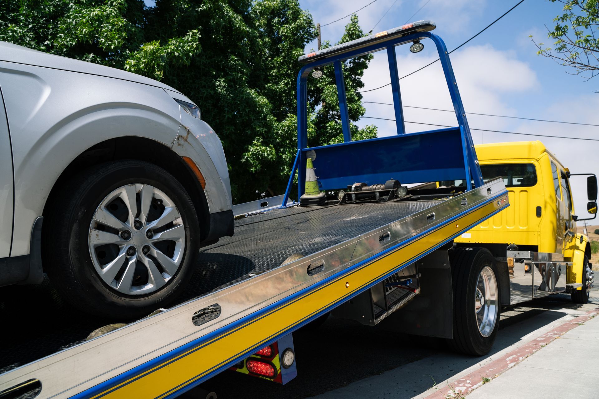 Sliver vehicle loading onto a flatbed tow truck.