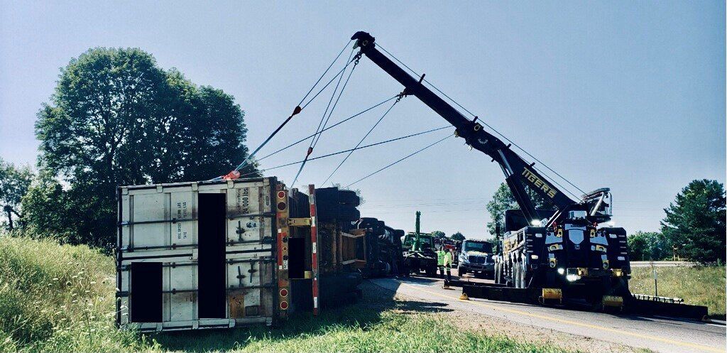 A Truck Is Being Towed by A Crane Down a Dirt Road — Battle Creek, MI — Tiger’s Towing