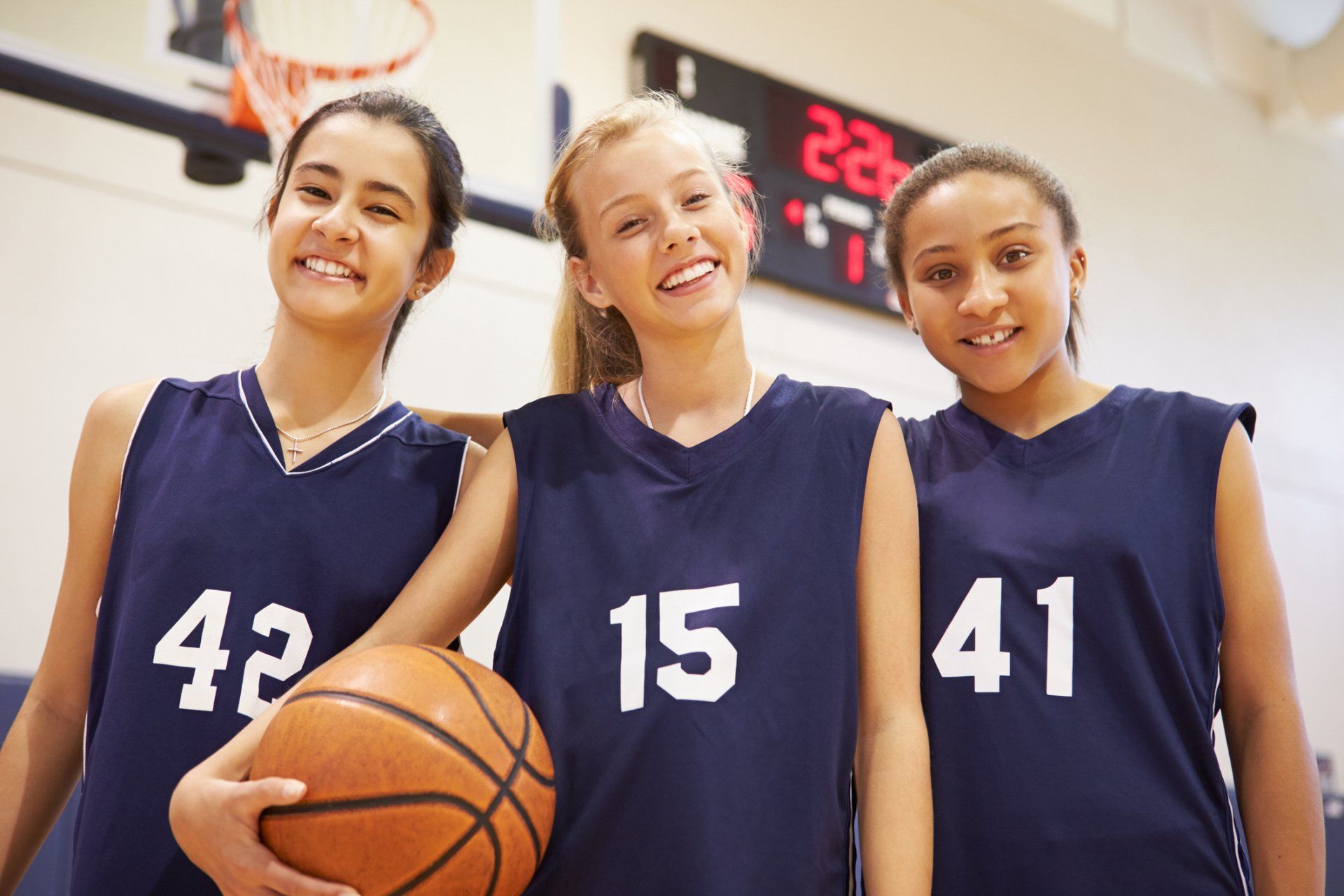 Three girls wearing basketball uniforms with the number 42 15 and 41 on them