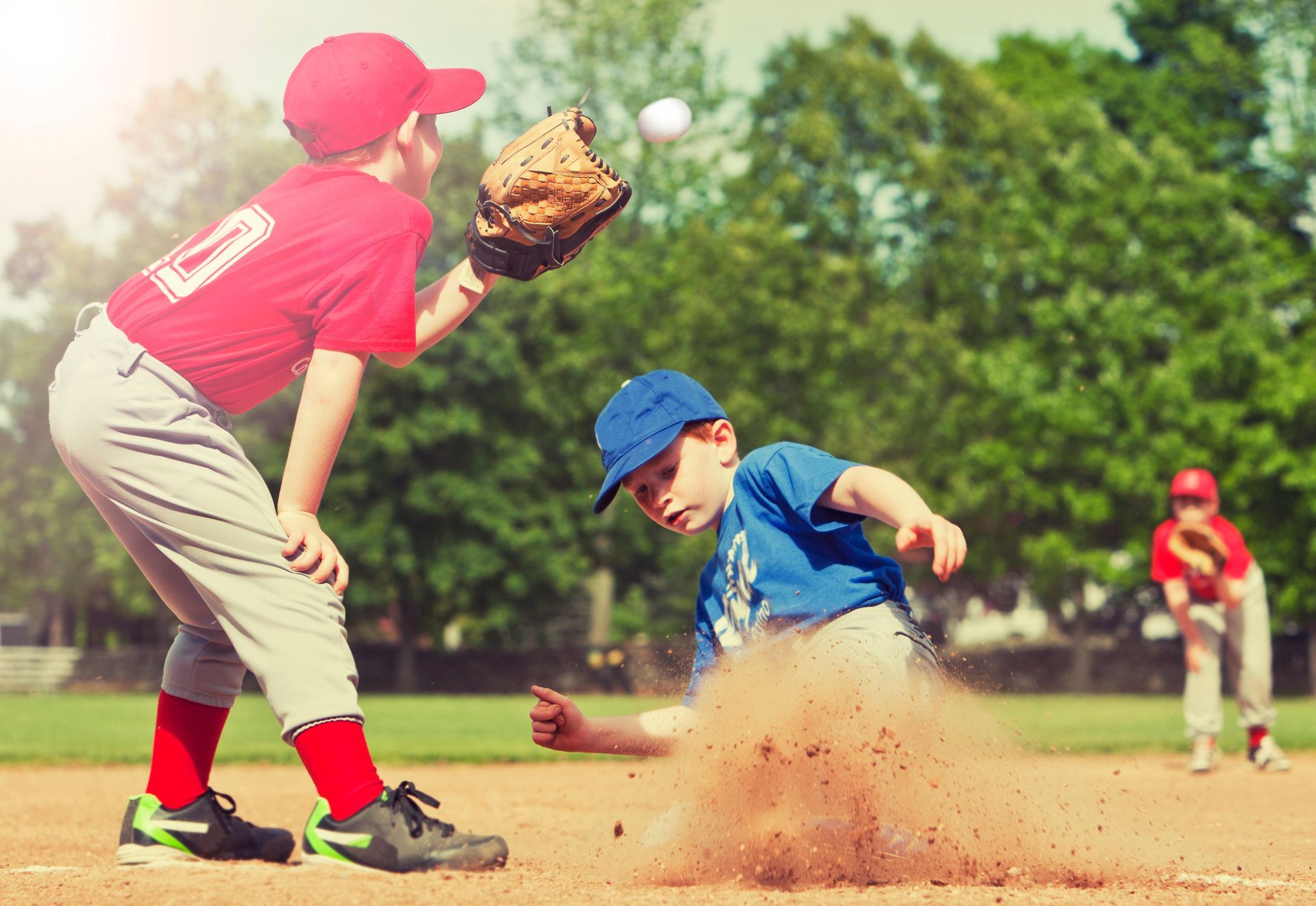Two young boys are playing baseball on a field.