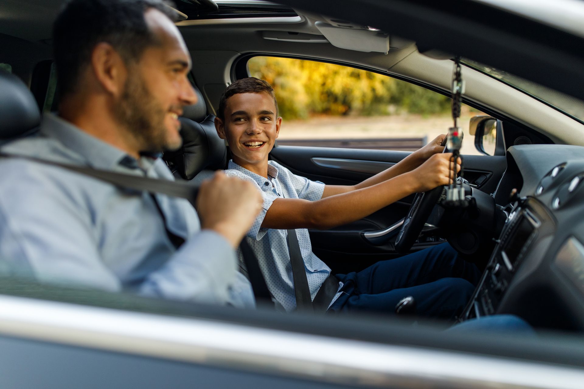 A man and a boy are sitting in a car.