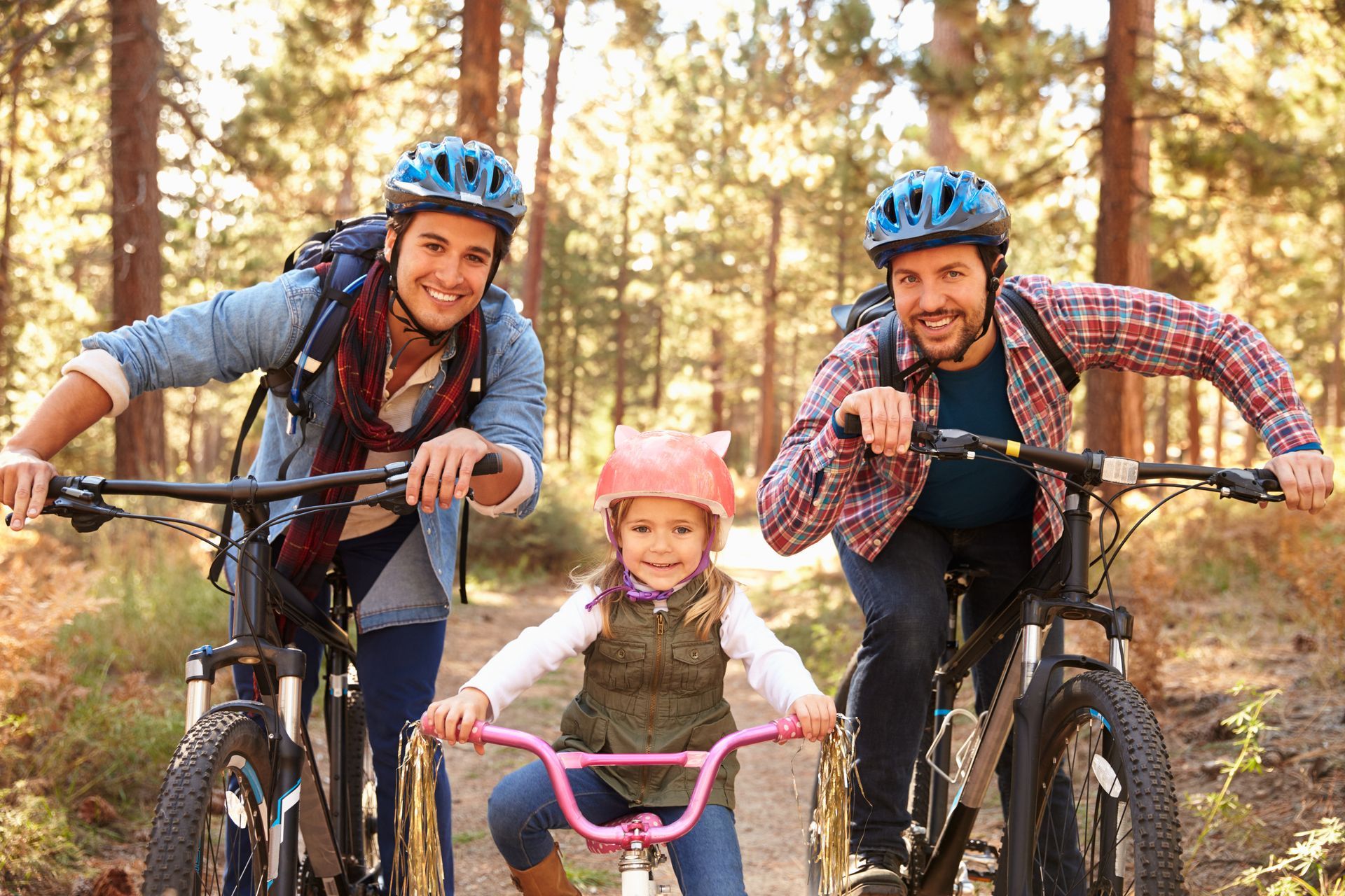 A family is riding bikes together in the woods.
