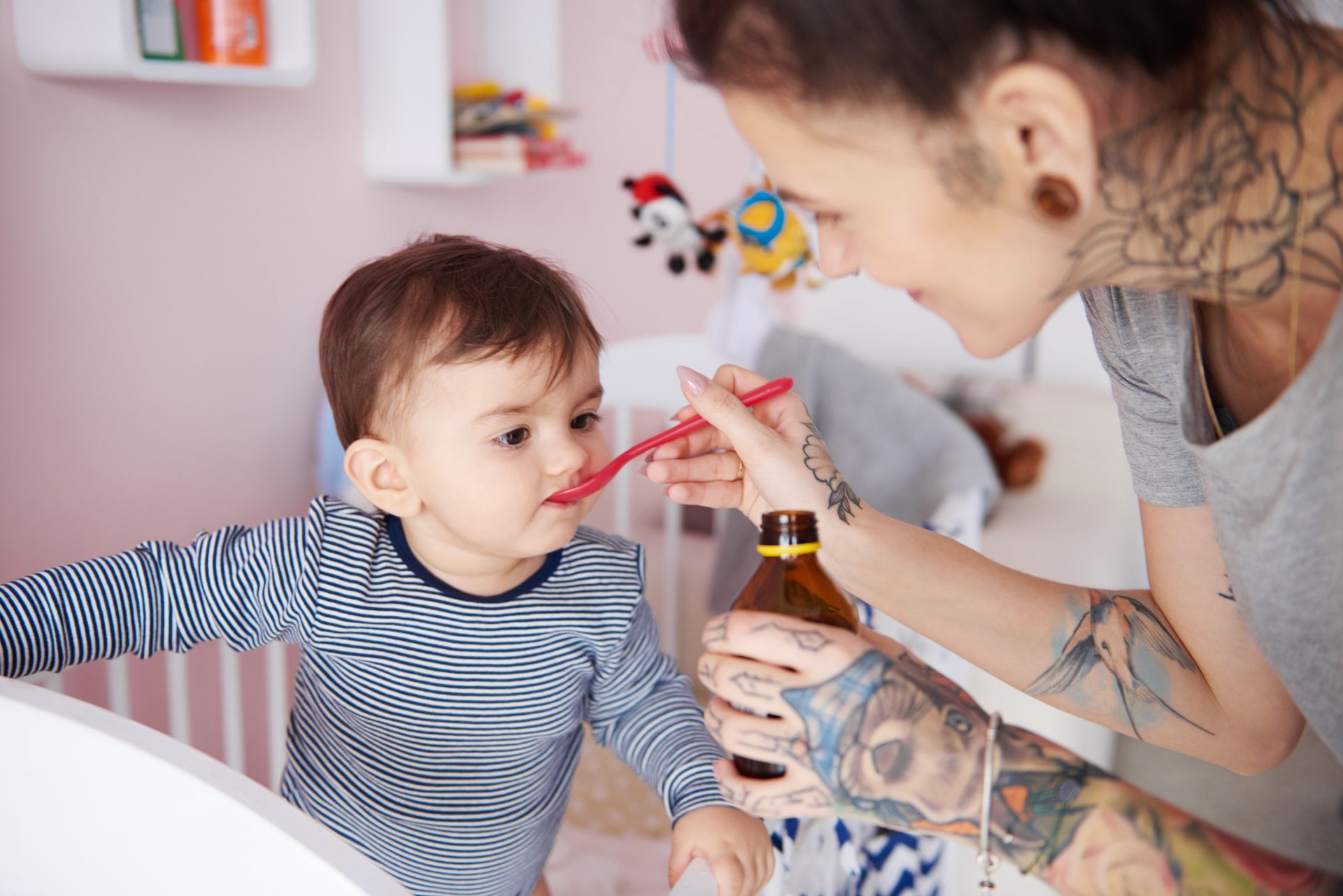A woman is feeding a baby with a spoon.