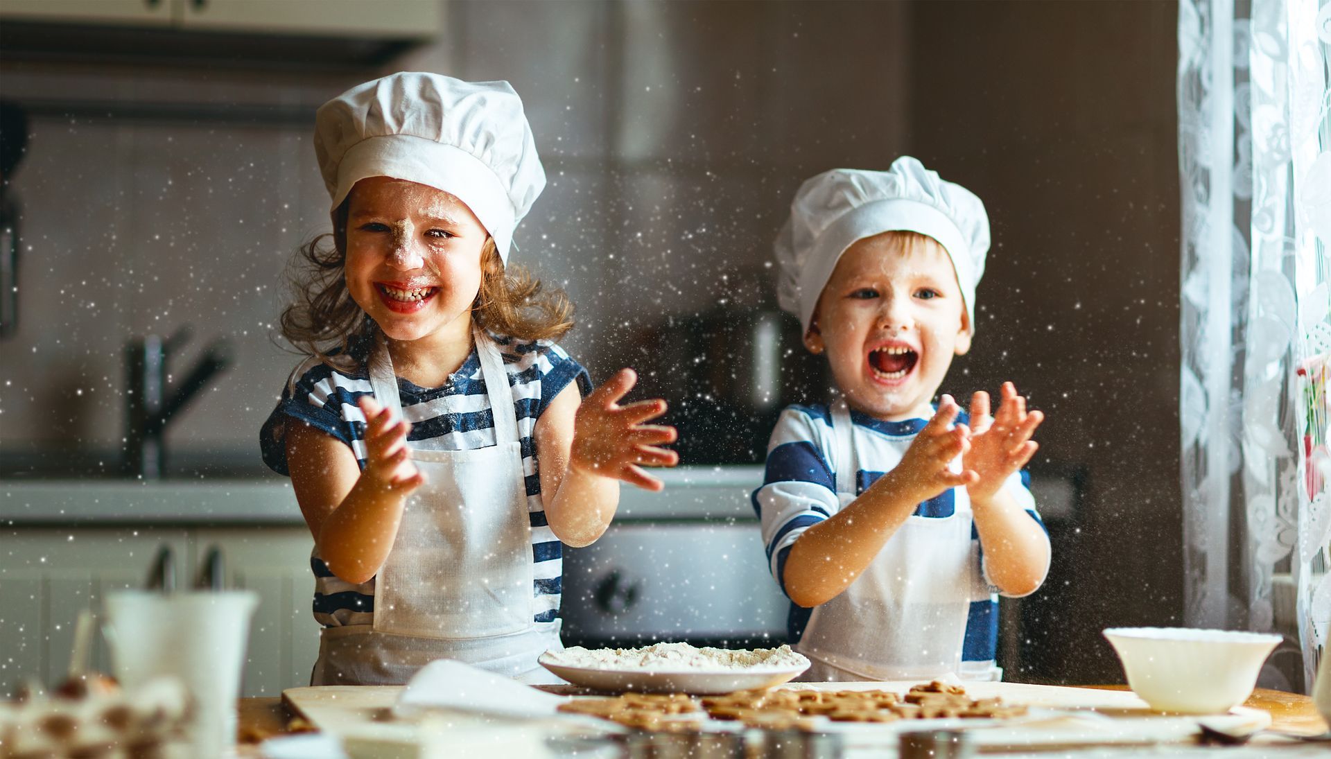 A boy and a girl are playing with flour in a kitchen.