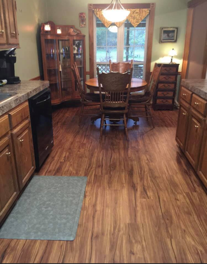 A kitchen with hardwood floors and a table and chairs