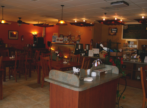 The inside of a restaurant with tables and chairs and a counter