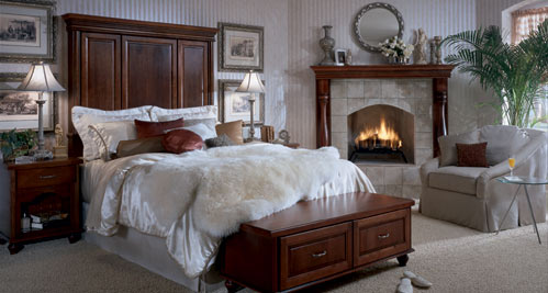 A bedroom with a fireplace and a king size bed