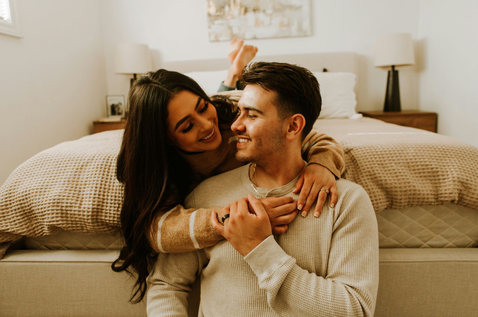 Couple smiling and embracing at home, symbolizing emotional connection and trust nurtured through Oakland couples therapy.