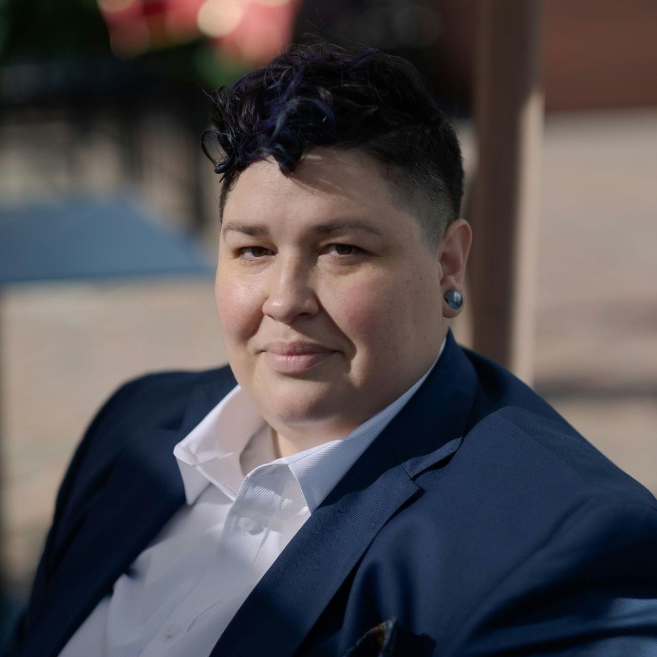 Individual sitting confidently outdoors in a suit, reflecting self-assurance and emotional healing through therapy for anxiety and depression in Oakland.