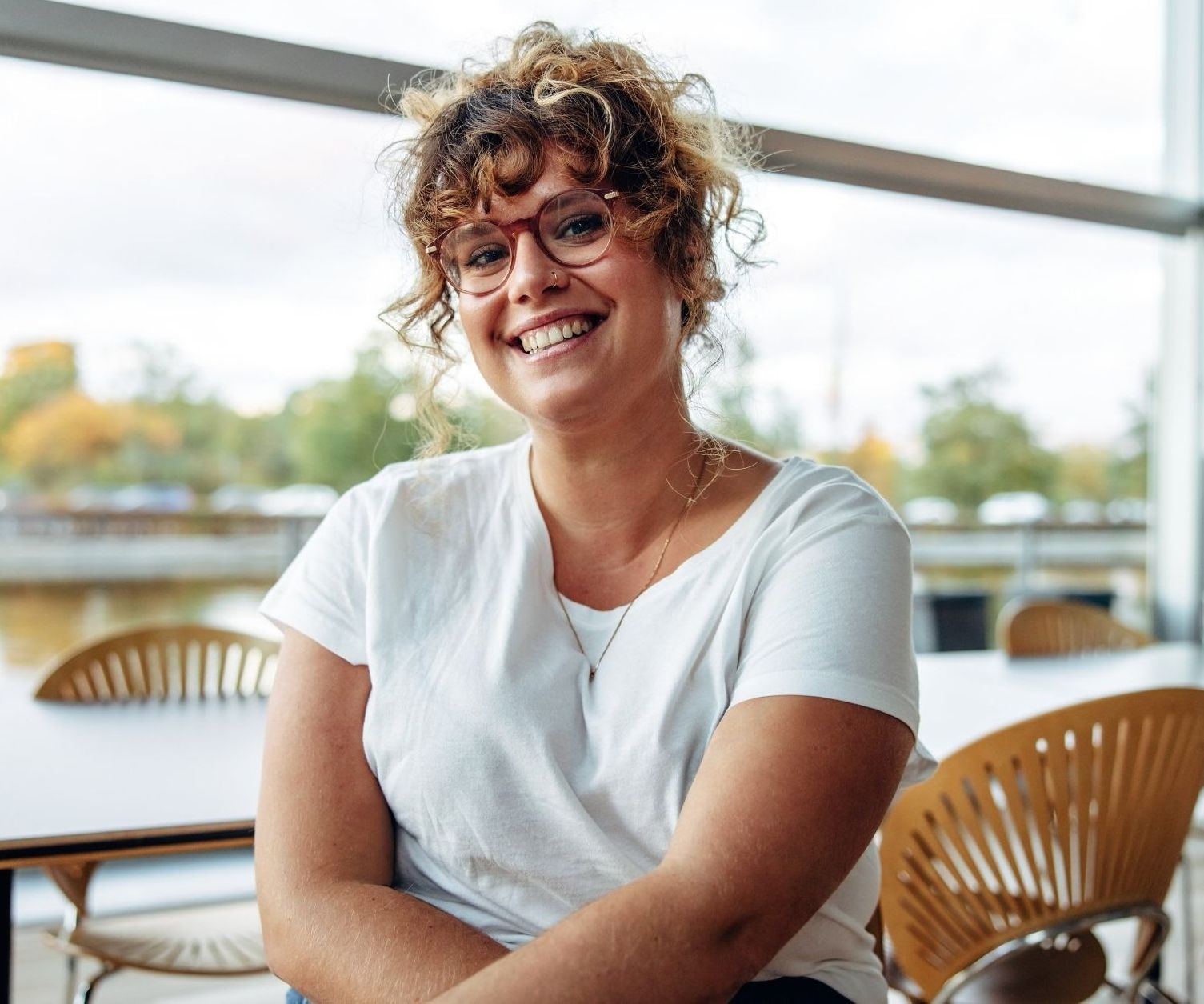 Smiling adult sitting at a table, representing supportive individual therapy in Oakland and online across California.