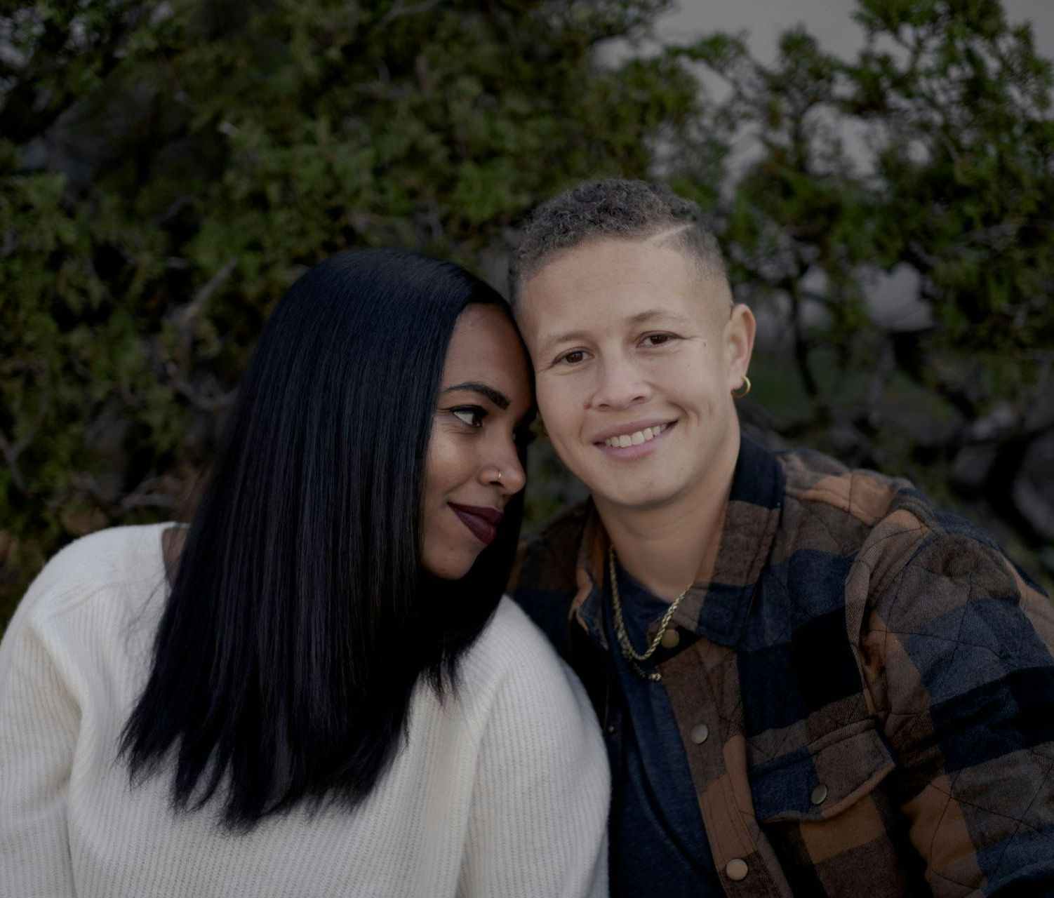 Smiling gay couple embracing outdoors, symbolizing joy, trust, and emotional connection supported through Oakland couples therapy