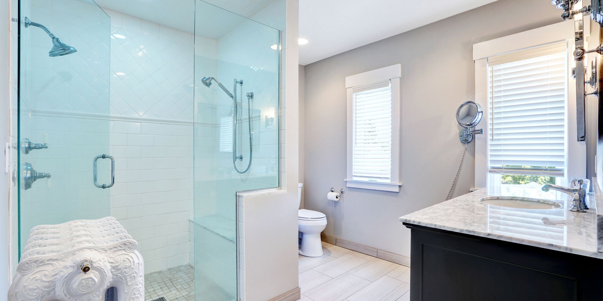 A bathroom with a walk in shower , toilet , sink and mirror.