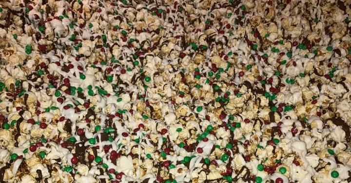 Popcorn mixed with colorful candy-coated pieces filling the frame.
