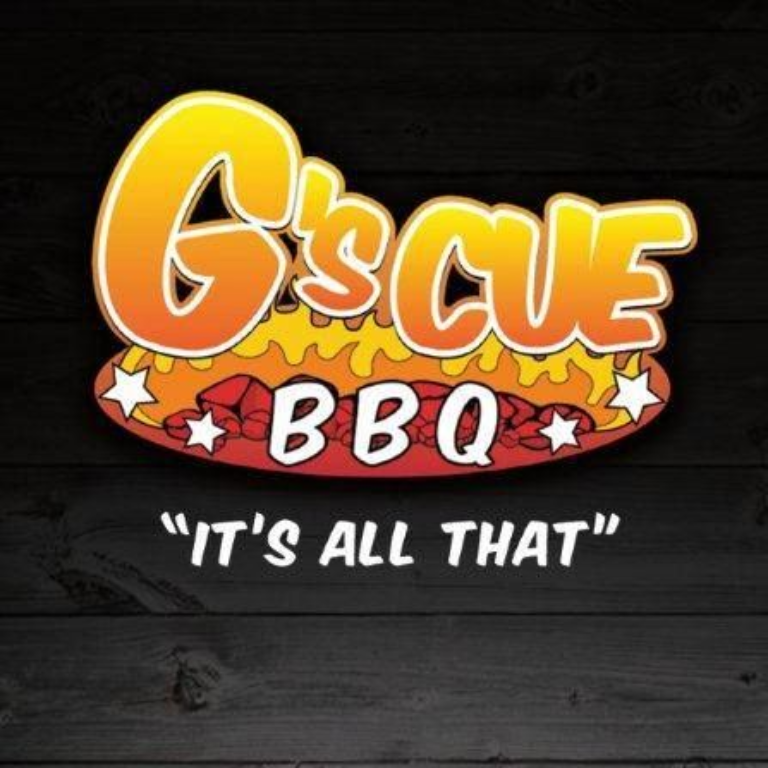 G’scue BBQ logo with orange and red lettering and the tagline “It’s all that” on a dark wood background