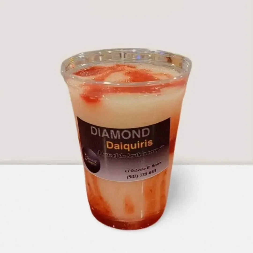 Diamond Daiquiris drink in a clear plastic cup with layered cream, red syrup, and ice cubes