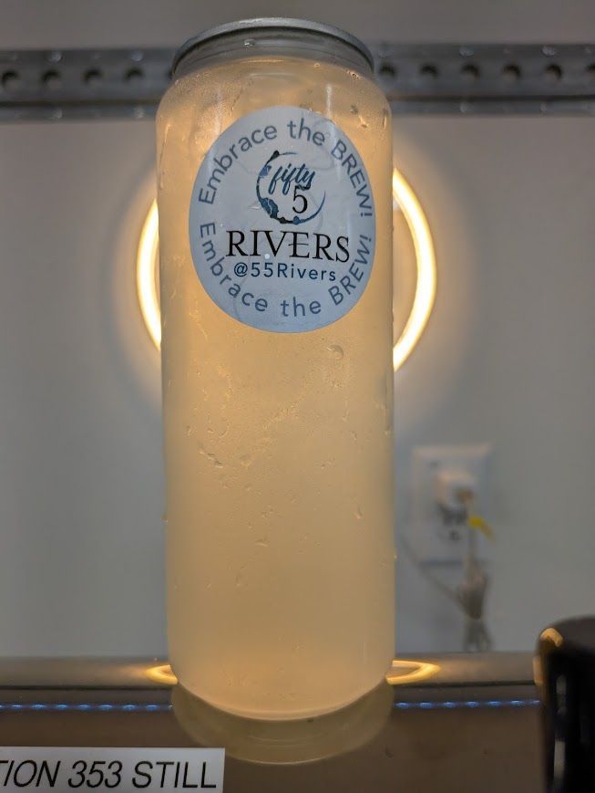 Frosted glass beer bottle labeled “Rivers” on a counter, lit from behind.