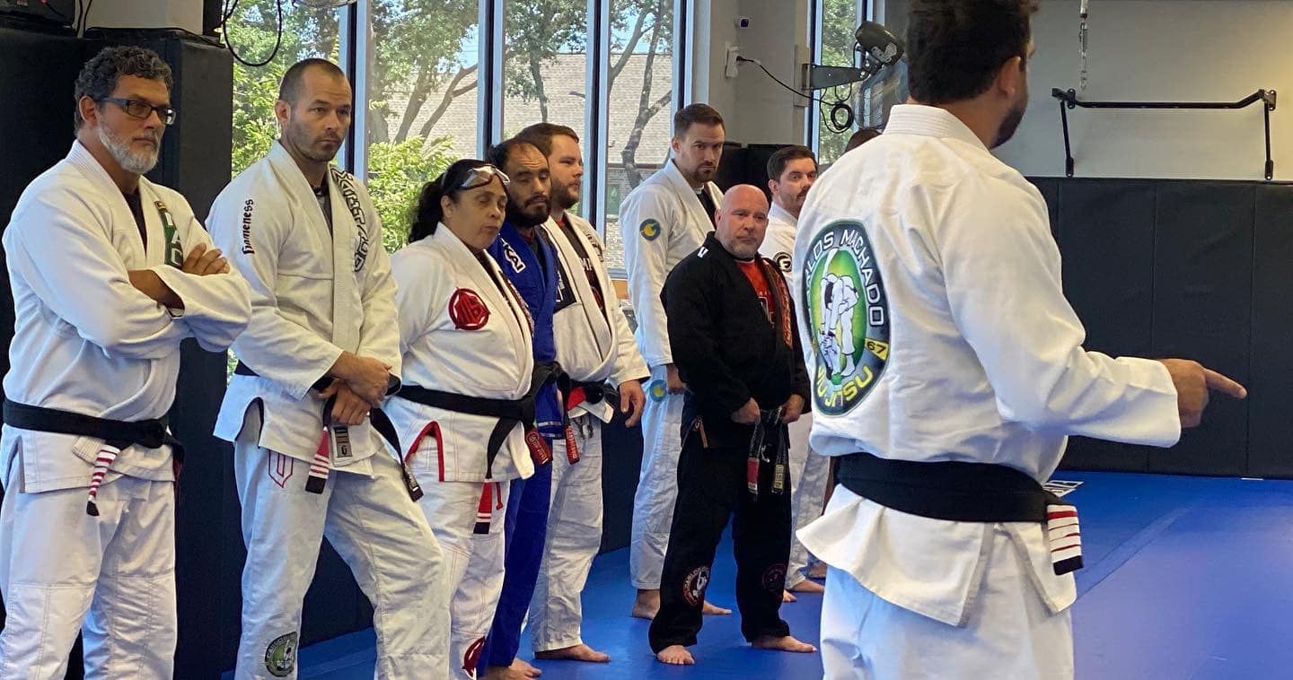 a group of people are standing in a line on a blue mat in a gym .