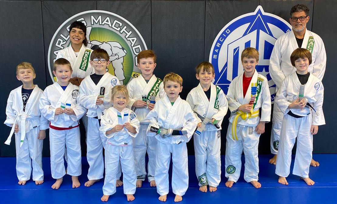 a group of young boys in white karate uniforms are posing for a picture .