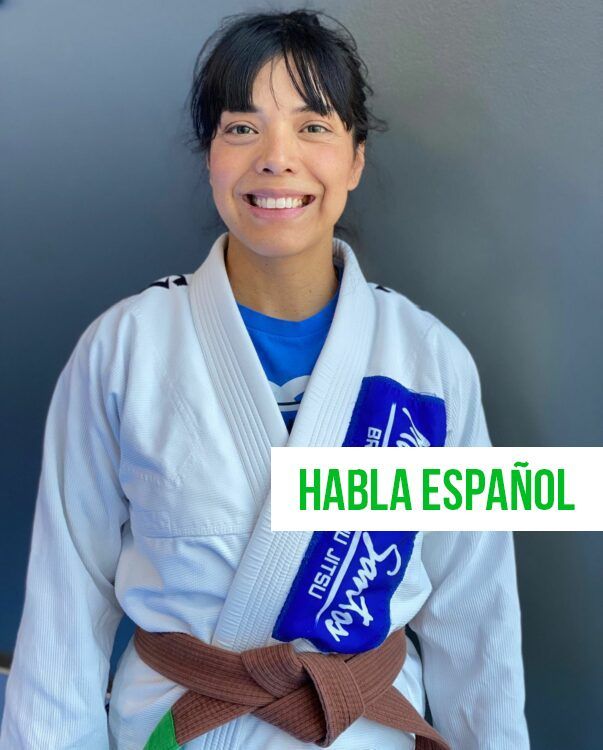 a woman is wearing a white kimono with a purple patch that says mario santos on it