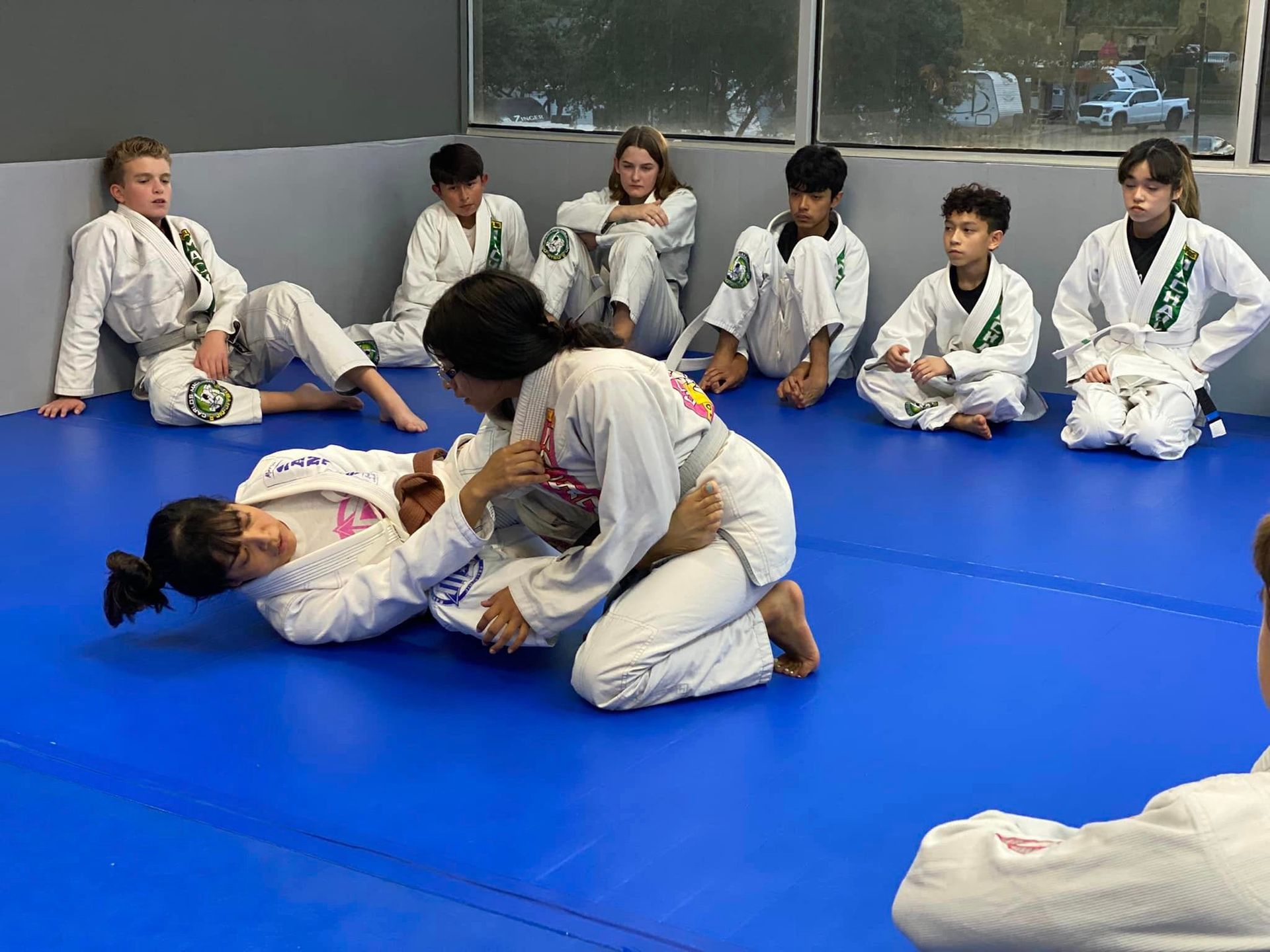 a group of young girls are standing on a blue mat