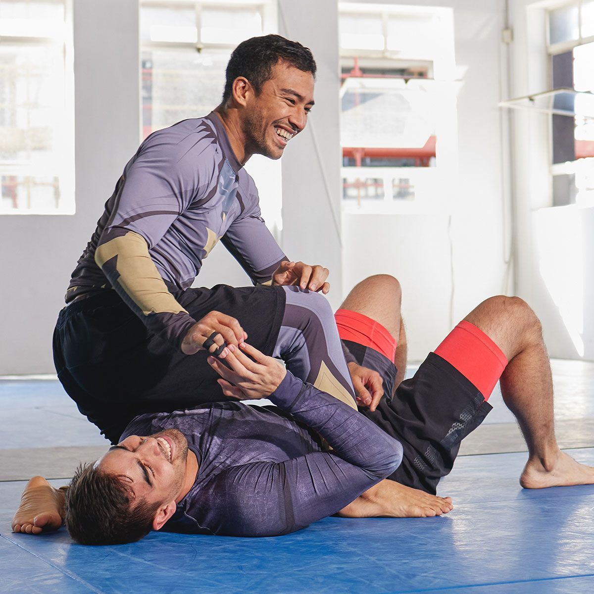 a man is laying on top of another man on a mat