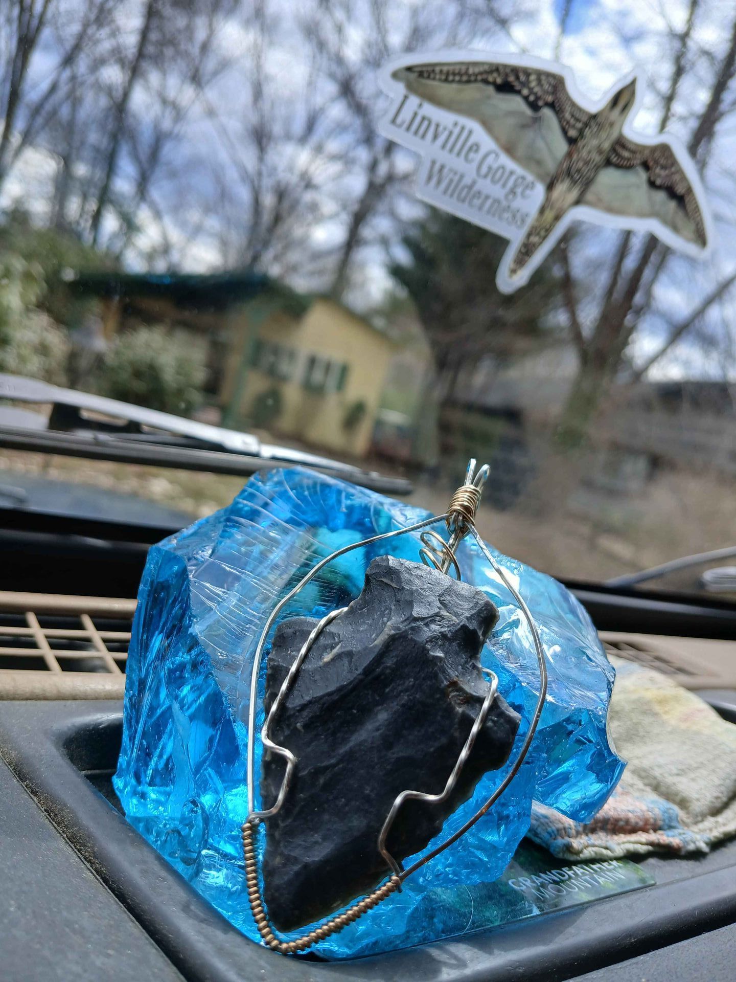 A large blue rock is sitting on the dashboard of a car.