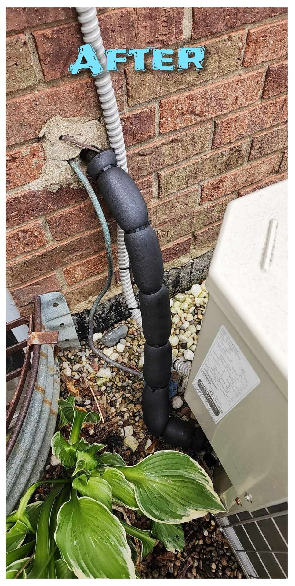 A picture of a pipe being installed on a brick wall.
