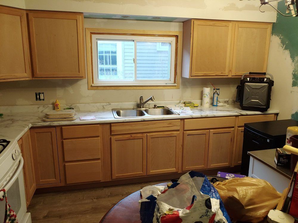 A kitchen with wooden cabinets and a window