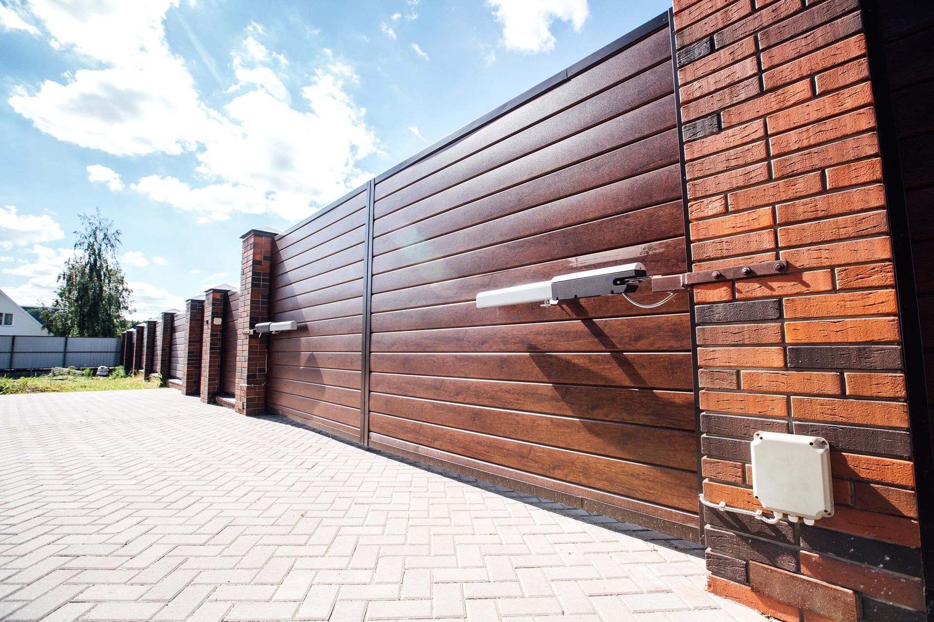 A large wooden sliding gate with a motor attached to it.
