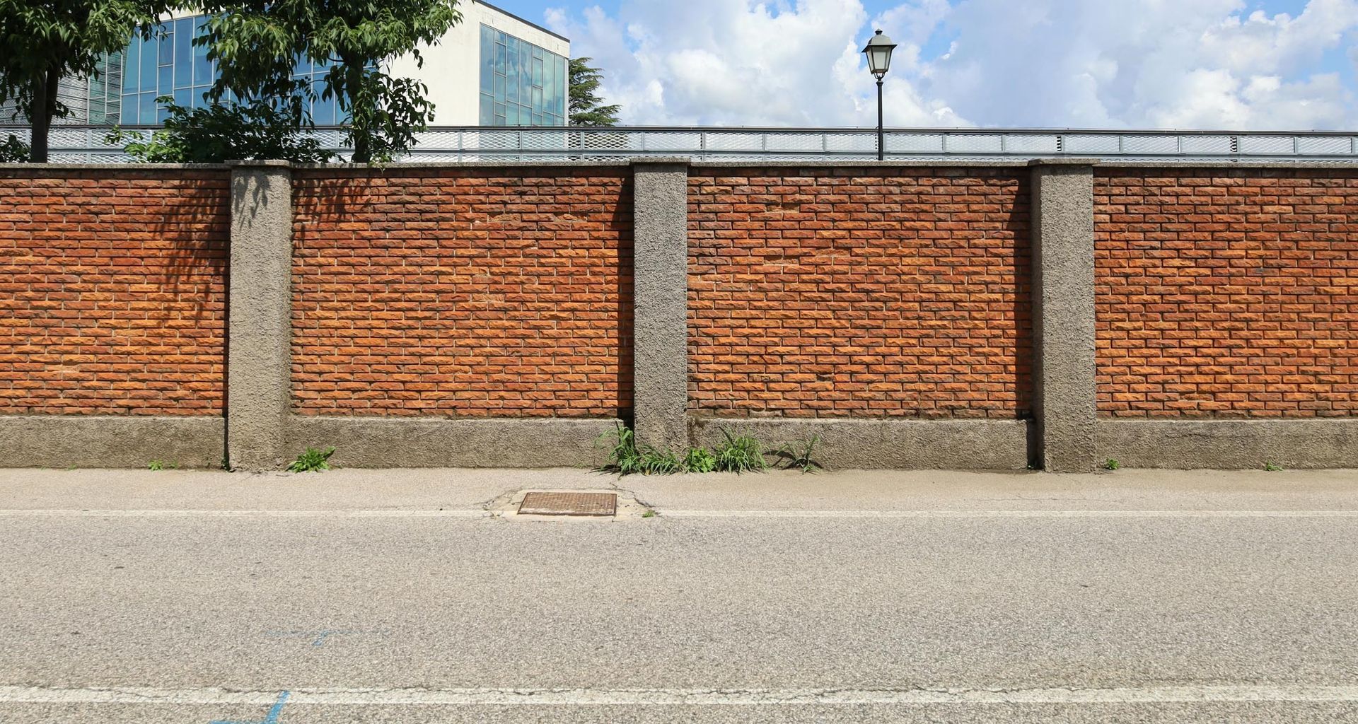 There is a brick wall along the side of the road.