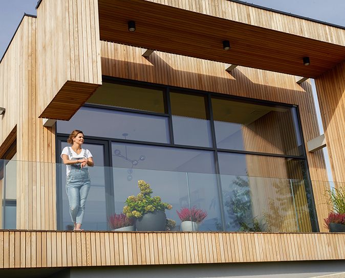 a woman standing on a balcony of a wooden house