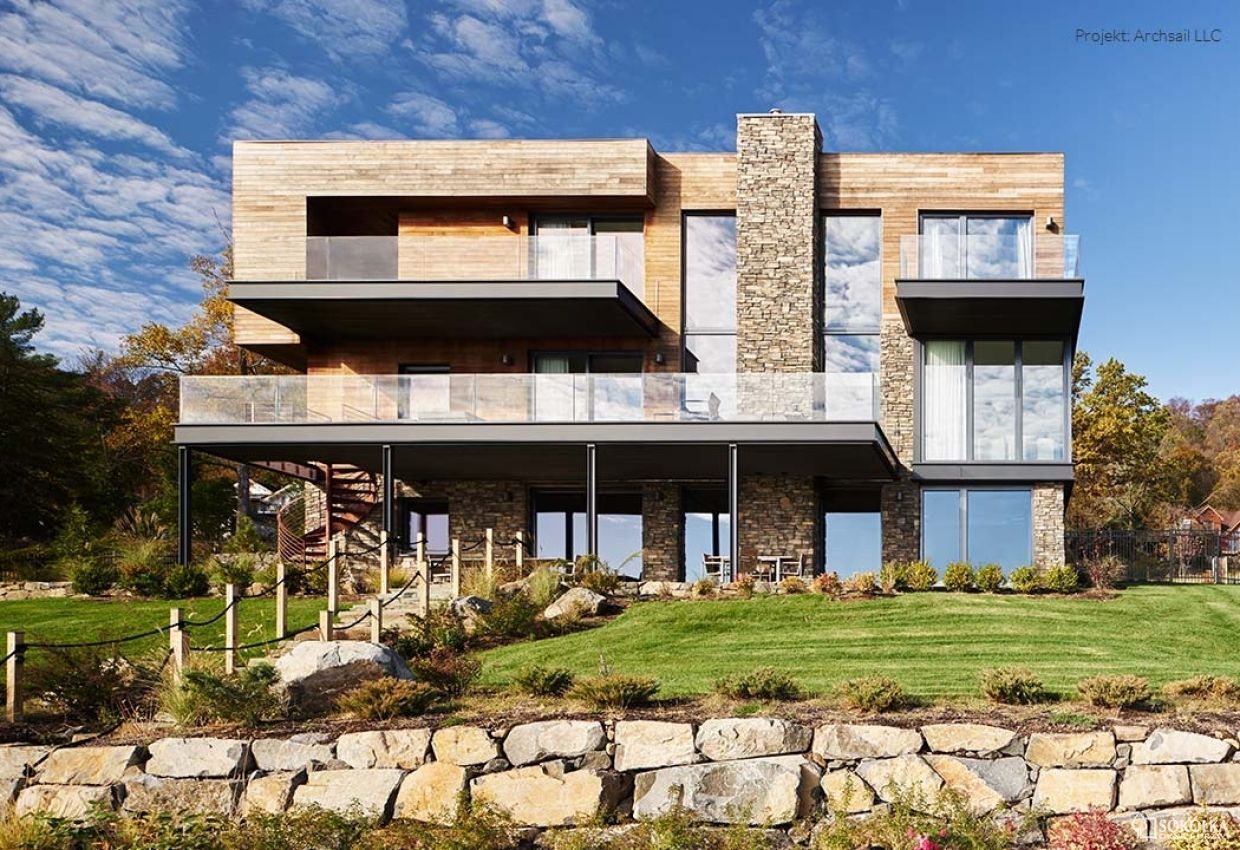 a large house with a lot of windows and a stone wall