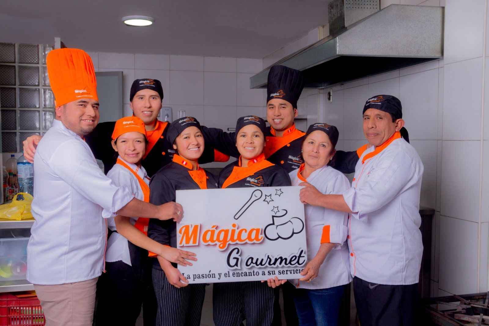 Un grupo de personas sosteniendo un cartel que dice magica gourmet