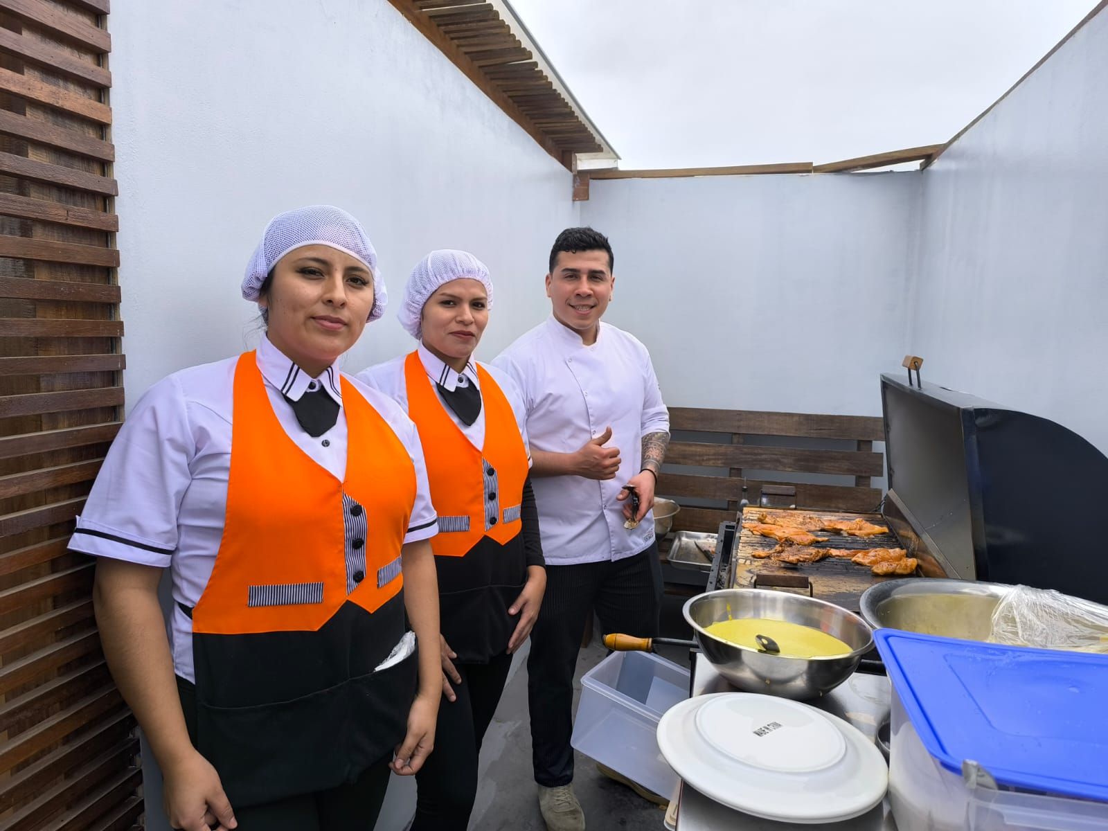 Un grupo de chefs están parados uno al lado del otro en una cocina.