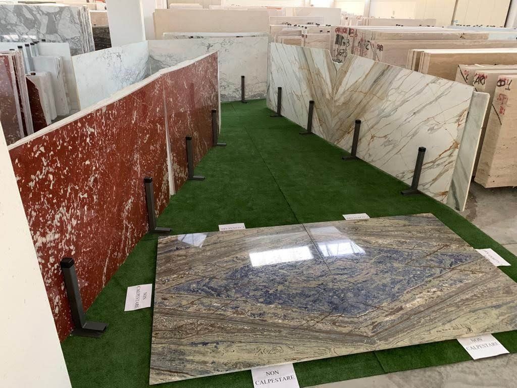 Esposizione di varie lastre di marmo in uno showroom, che mostrano colori e motivi diversi.