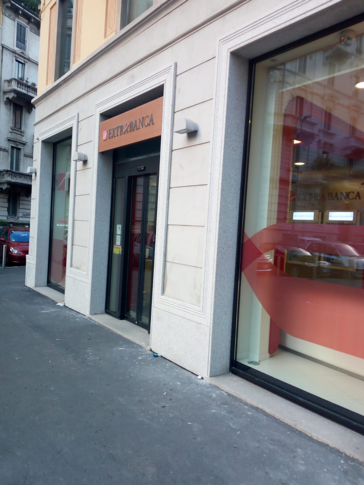 Esterno di un edificio della Banca Intesa Sanpaolo con porte e finestre in vetro, Milano, Italia.