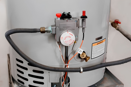 Gas water heater with gray vent hose and exposed wiring in a utility area