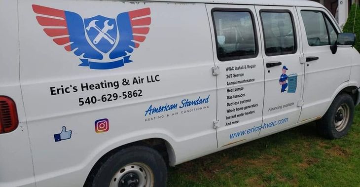 White HVAC service van with Eric’s Heating & Air LLC logo and contact information parked on grass.