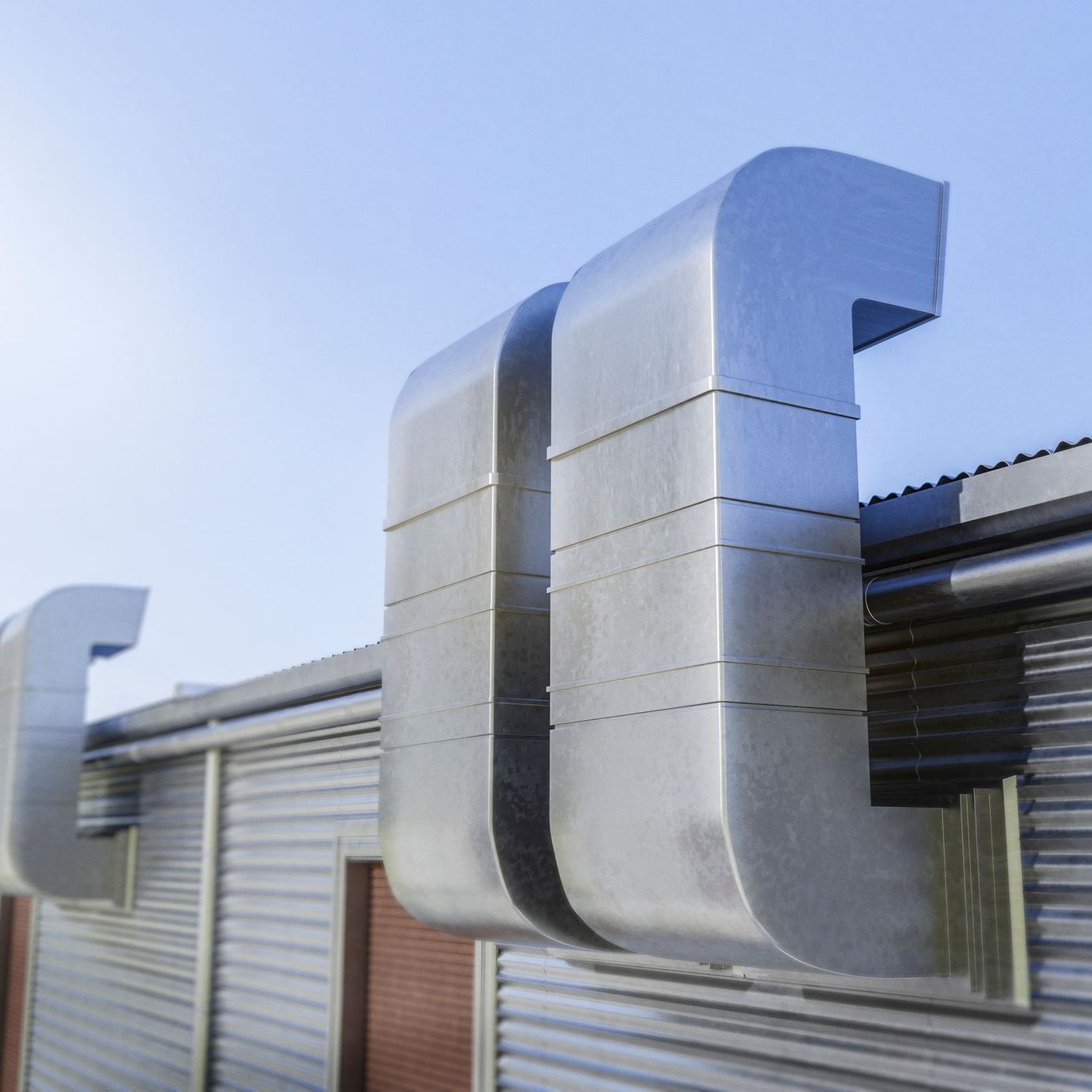 A metal pipe is attached to the side of a building.