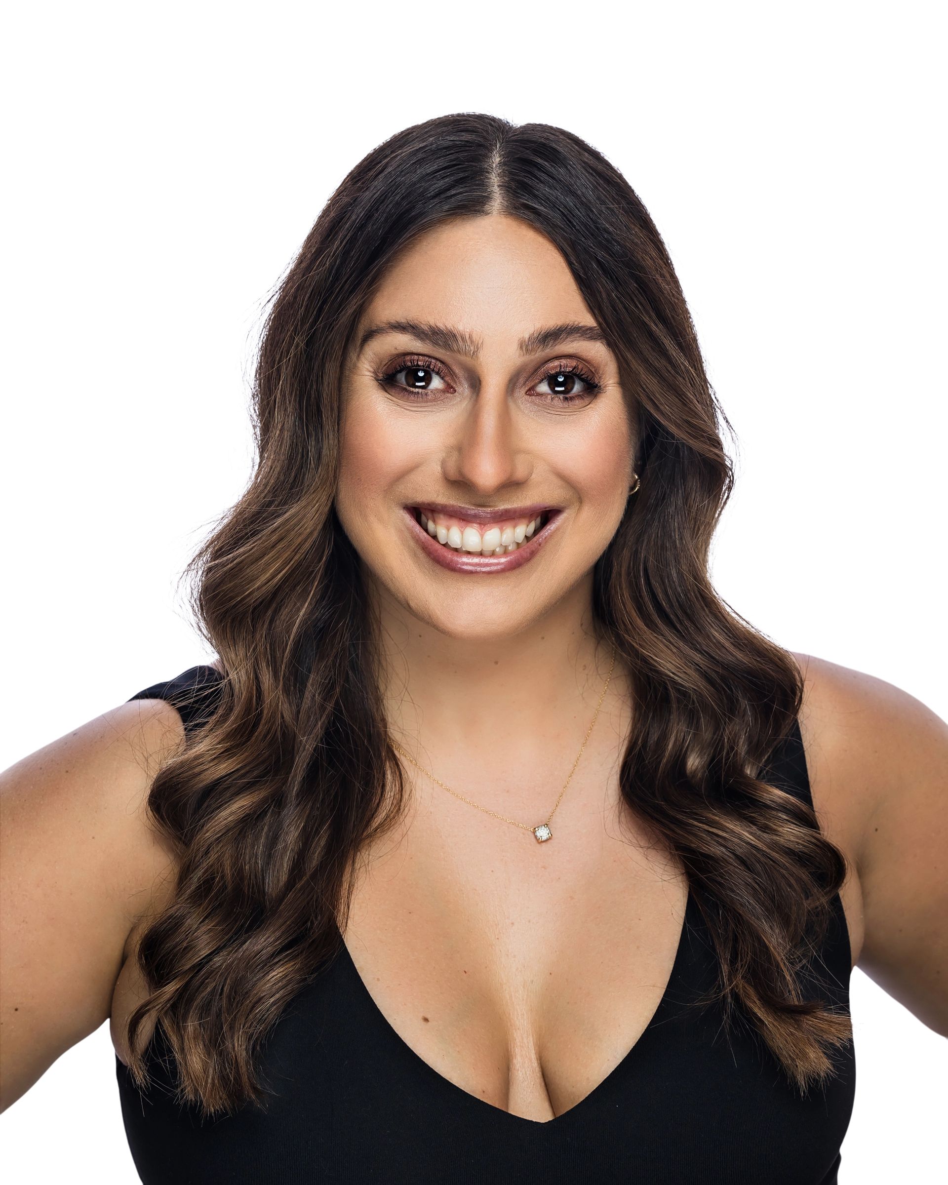 Portrait of a smiling person with long wavy dark hair, wearing a black top against a white background