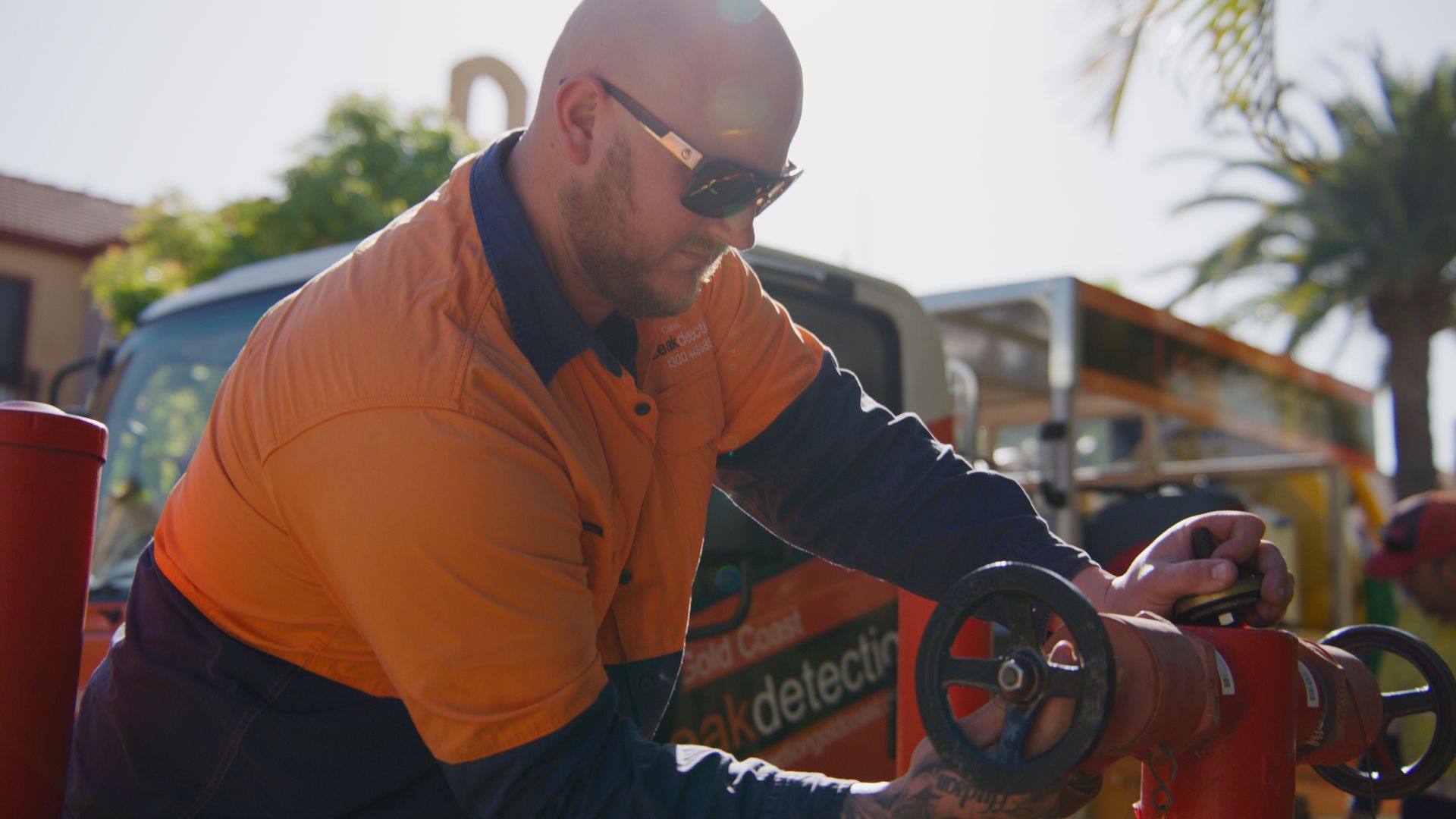 A Man in an Orange Shirt is Working on a Fire Hydrant — Tweed Heads Leak Detection in Casuarina, NSW