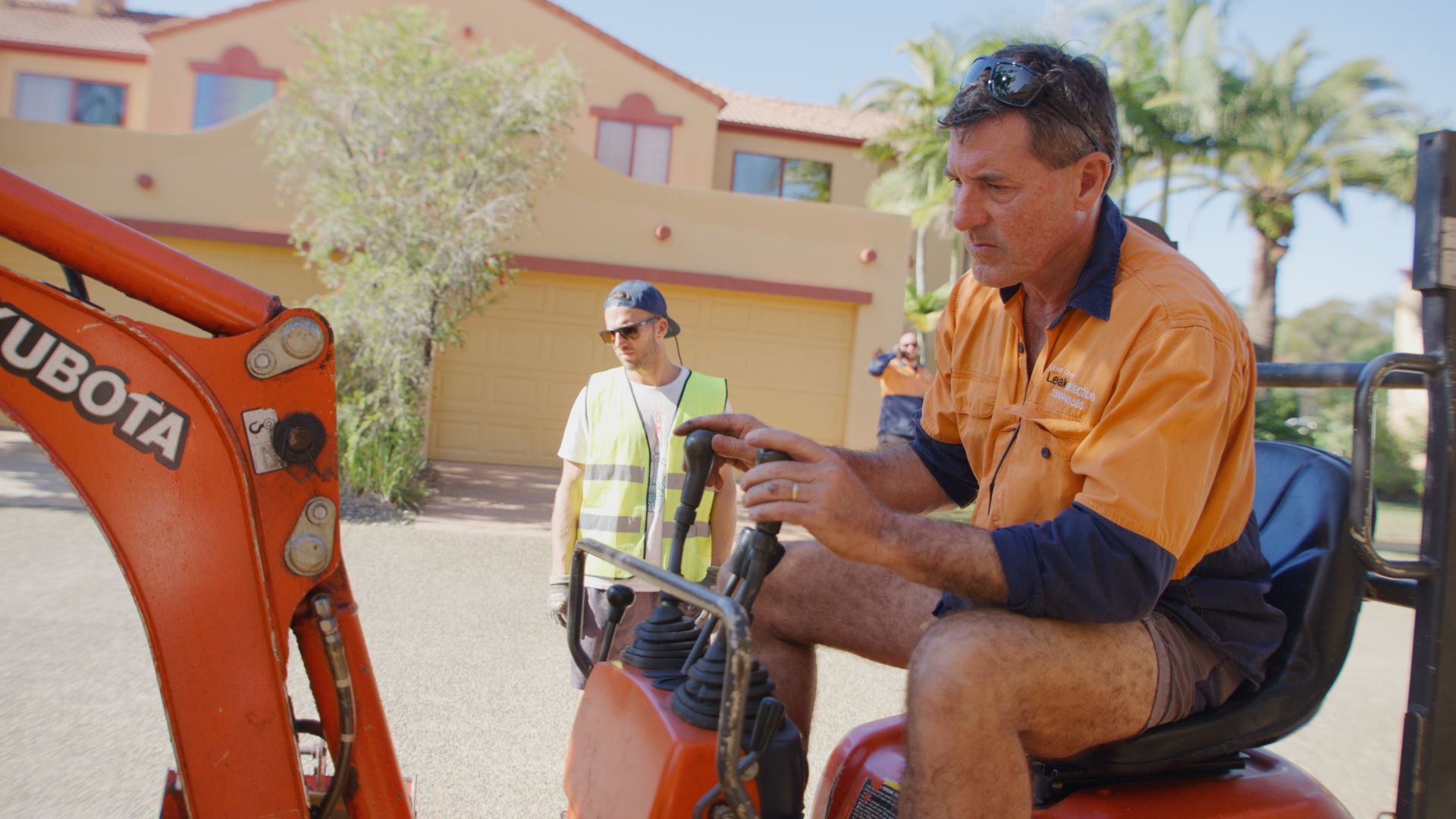 Two Men Are Cleaning A Manhole Cover With A High Pressure Washer — Tweed Heads Leak Detection in Casuarina, NSW