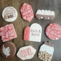 Assorted pink, white, and brown hand-decorated Easter cookies arranged on a surface.