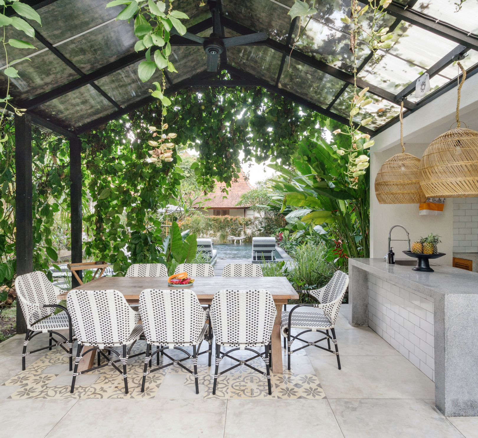 A dining room with a table and chairs under a glass roof