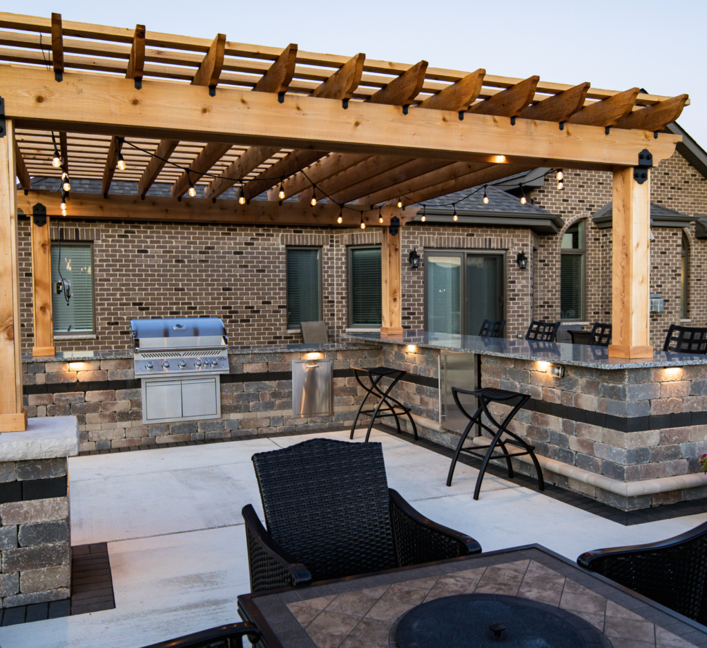 A patio with a table and chairs under a wooden pergola.