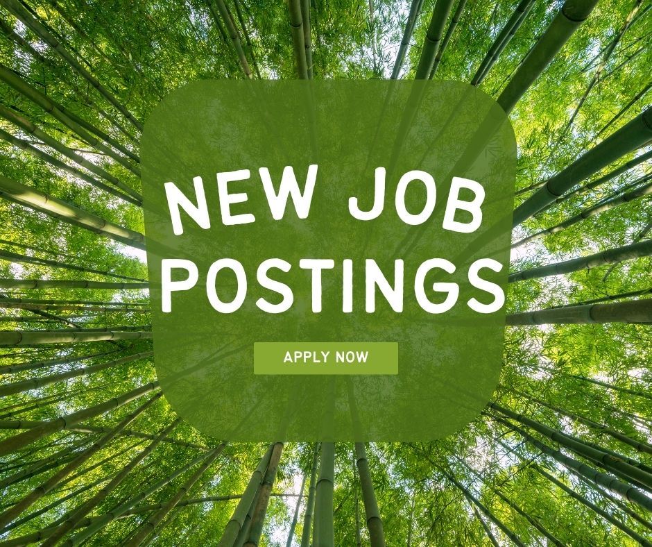 A green sign that says new job postings with trees in the background